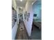 Inviting hallway with wood floors and decorative rug leading to a bedroom with a ceiling fan at 6365 Se 12Th Ln, Ocala, FL 34472