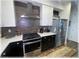 Modern kitchen featuring stainless steel appliances, white cabinets, and a stylish backsplash, creating a sleek and functional space at 6365 Se 12Th Ln, Ocala, FL 34472