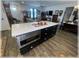 Open concept kitchen island with stainless steel appliances and black cabinets is the focal point of the spacious entertaining area at 6365 Se 12Th Ln, Ocala, FL 34472