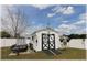 White outbuilding with black trim, rail road crossing sign, and small trailer parked nearby at 6365 Se 12Th Ln, Ocala, FL 34472
