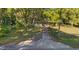 Driveway to the property with a combination of grassy areas and mature trees at 6700 Nw 57Th Ave, Ocala, FL 34482