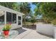 View of the back patio with a screened-in porch and manicured landscaping, including flowering plants at 712 Harper Pl, Lady Lake, FL 32159