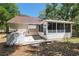 Exterior of the home featuring a screened-in patio, concrete patio, and lush backyard landscaping at 712 Harper Pl, Lady Lake, FL 32159