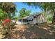 Landscaped backyard featuring a screened-in porch, flowers, and shady trees, offering privacy and charm at 712 Harper Pl, Lady Lake, FL 32159