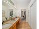 Bathroom with dual sinks, granite counters, and a view of the tub/shower at 712 Harper Pl, Lady Lake, FL 32159