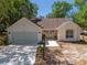 Charming single-story home with a two-car garage, a well-manicured lawn and mature trees offering great curb appeal at 712 Harper Pl, Lady Lake, FL 32159