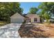 Inviting home exterior featuring a manicured lawn, attached garage, and a charming entryway with flower pots at 712 Harper Pl, Lady Lake, FL 32159