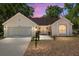 Charming one-story home featuring a two-car garage, a manicured lawn, and a cozy front porch at sunset at 712 Harper Pl, Lady Lake, FL 32159