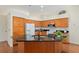 Open kitchen with wood cabinets, center island with sink, and granite countertops at 712 Harper Pl, Lady Lake, FL 32159