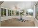 Bright enclosed lanai with ceiling fan and view of yard through many windows at 712 Harper Pl, Lady Lake, FL 32159