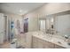 Bright bathroom featuring a shower with glass door, large mirror above the sink and custom cabinets at 7687 Sw 63Rd Place Rd, Ocala, FL 34474