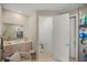 Bathroom featuring a shower with glass door, double sink, a toilet, a chair and custom cabinets at 7687 Sw 63Rd Place Rd, Ocala, FL 34474