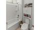 Bright bathroom featuring a white shower-tub combination and a matching storage cabinet above the toilet at 7687 Sw 63Rd Place Rd, Ocala, FL 34474