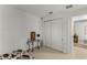 Bedroom featuring a closet with sliding doors and a decorative painting above a glass table with metal legs at 7687 Sw 63Rd Place Rd, Ocala, FL 34474
