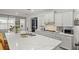 Kitchen with an oversized island, seating, white countertops, white cabinets and stainless steel appliances at 7687 Sw 63Rd Place Rd, Ocala, FL 34474