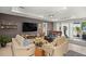 Living room with neutral tones, a large TV, ceiling fan, and views of the lanai and the water beyond at 7687 Sw 63Rd Place Rd, Ocala, FL 34474