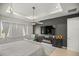 Well-lit main bedroom with a tray ceiling, ceiling fan, TV and a fireplace below the tv at 7687 Sw 63Rd Place Rd, Ocala, FL 34474