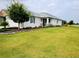 Well-maintained lawn and landscape showcasing a home with shutters and manicured flowerbeds at 7696 Sw 86Th Ct, Ocala, FL 34481