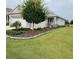 Charming one-story home featuring a manicured lawn and beautiful landscaping with stone accents at 7696 Sw 86Th Ct, Ocala, FL 34481