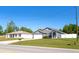 Property featuring a long driveway and a two-car garage, all surrounded by a well-maintained lawn at 8004 Juniper Rd, Ocala, FL 34480
