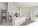 Modern kitchen featuring stainless steel appliances, a breakfast bar, and an open layout to the living area at 8661 Juniper Rd, Ocala, FL 34480
