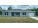 Charming single-story home features a freshly painted exterior, a well-manicured lawn, and an attached single-car garage at 87 Guava Pass Dr, Ocklawaha, FL 32179