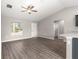 Open living room with vaulted ceiling, wood-look floors, and a view into the kitchen at 87 Guava Pass Dr, Ocklawaha, FL 32179