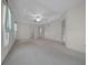 Spacious main bedroom featuring tray ceilings, large windows, and neutral carpeting at 8895 Sw 57Th Court Rd, Ocala, FL 34476