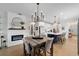 Dining area with a fireplace, wood table, modern chandelier, and open view into the kitchen at 8951 Sw 58Th Street Rd, Ocala, FL 34481