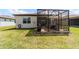 View of the home's exterior featuring a screened-in patio area and well-maintained lawn at 8951 Sw 58Th Street Rd, Ocala, FL 34481