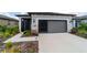 View of a single story home's driveway, garage, and a screen enclosed porch at 8951 Sw 58Th Street Rd, Ocala, FL 34481