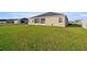 Large, well-maintained backyard with green grass and a view of the home's exterior at 9074 Se 48Th Court Rd, Ocala, FL 34480