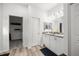 Clean, well-lit bathroom with double sinks, white cabinets, and a walk-in closet at 9074 Se 48Th Court Rd, Ocala, FL 34480