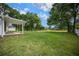 Expansive backyard with lush green grass and a view of the covered patio at 10337 Sw 74Th Ter, Ocala, FL 34476
