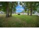 Lush backyard with mature trees, a chain-link fence, and views of the home's back exterior at 10337 Sw 74Th Ter, Ocala, FL 34476