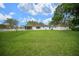 Spacious backyard with manicured lawn, screened porch, and white fence, ideal for outdoor enjoyment at 10337 Sw 74Th Ter, Ocala, FL 34476