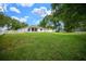 Expansive backyard featuring lush green lawn, mature trees, and a white picket fence at 10337 Sw 74Th Ter, Ocala, FL 34476