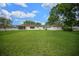 Wide view of the large, grassy backyard with a screened-in porch and separate outbuilding at 10337 Sw 74Th Ter, Ocala, FL 34476