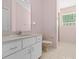 Bathroom featuring a white vanity, neutral toilet, and walk-in shower with patterned glass block window at 10337 Sw 74Th Ter, Ocala, FL 34476