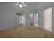 Spacious bedroom featuring neutral carpet, ceiling fan, and an ensuite bathroom for convenience at 10337 Sw 74Th Ter, Ocala, FL 34476