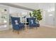 Inviting sitting area with blue chairs, decorative pillows, a mirrored wall, and a front door view at 10337 Sw 74Th Ter, Ocala, FL 34476