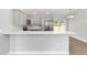 This kitchen features gray cabinets, stainless steel appliances, and a breakfast bar overlooking the open floor plan at 10374 Se 126Th Ln, Belleview, FL 34420