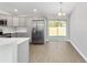 Modern kitchen with stainless steel appliances, gray cabinetry, and access to the backyard through sliding glass doors at 10374 Se 126Th Ln, Belleview, FL 34420