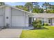 Inviting single-story home with an attached garage, featuring lush green lawn and a cozy entrance at 10441 Sw 85Th Ct, Ocala, FL 34481