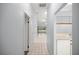 Bright hallway with tile flooring leading to a spacious room with sliding glass doors, showcasing natural light at 10441 Sw 85Th Ct, Ocala, FL 34481