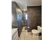Modern bathroom with dark gray tiling, featuring a toilet, glass shower, and vanity at 1047 Ne 19Th St, Ocala, FL 34470