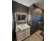 Modern bathroom features a vanity, a stylish mirror, a glass shower, and elegant dark gray tiling at 1047 Ne 19Th St, Ocala, FL 34470