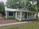 Charming home featuring a welcoming front porch with white railings and a well-maintained yard with mature trees at 1047 Ne 19Th St, Ocala, FL 34470
