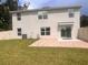 View of the back exterior featuring a brick patio, sliding glass doors, and a spacious grassy yard at 11136 Se 69Th Ter, Belleview, FL 34420