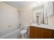 The bathroom features a combined shower and tub, with a wooden vanity and a neutral color scheme at 1115 Silver Rd, Ocala, FL 34472